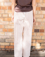 Back view of Destiny straight-leg pants with chocolate brown vertical stripes on a cream background.