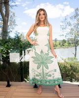 Woman wearing a green and cream palm print linen-cotton maxi dress with adjustable straps and A-line silhouette.