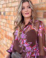 Woman wearing high-rise genuine leather shorts in a tailored, structured fit against a brick wall.