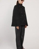 Black wool-blend military cape with a high neckline, double-breasted buttons, and a structured, boxy silhouette.