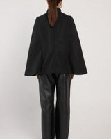 Back view of a black wool-blend military cape with a high neckline and structured, boxy silhouette.