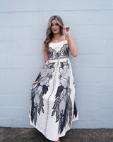 Eloise El Tropico sundress in cream linen-cotton blend with black tropical print, adjustable straps, and pockets.