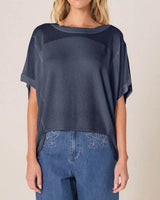 Navy blue relaxed-fit knit top with a boat neckline and short sleeves, worn with blue jeans.