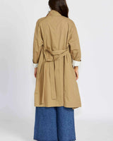 Back view of a tan cotton nylon Eva trenchcoat with a tie waist and white cuffed sleeves.