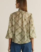 Back view of a green plaid pussybow blouse with elasticated sleeves and a relaxed, flared fit.