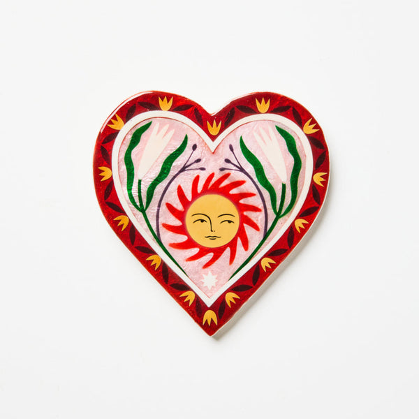 Decorative heart-shaped plate with a sun design on a white background
