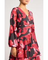Faith floral mini dress featuring a bold red and black floral print, wrap-style V-neck, and long sleeves with tie waist.