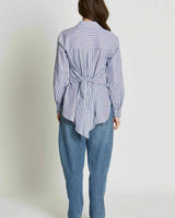 Blue and white striped 100% cotton Georgina shirt featuring a wrap-style back tie, worn with blue jeans.