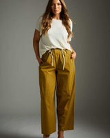 Woman wearing relaxed-fit chartreuse Good Karma pants with an elastic drawstring waistband and side pockets.