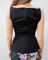 Back view of a black sleeveless Hannah apron top with a boat neckline, side ruching, and an invisible back zipper.
