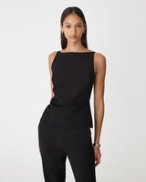 Sleeveless black Hannah apron top with a boat neckline, side ruching, and a structured peplum hem.
