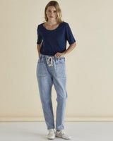 Model wearing light blue straight-leg jeans with an elasticated drawstring waist, drop-crotch, and front pockets.
