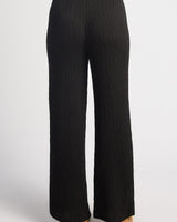Black high-waisted straight-leg pants in textured jersey fabric with a seamless back zip closure.