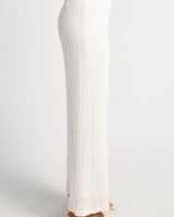 White high-waisted straight-leg pants in textured jersey fabric with a flattering draped silhouette.