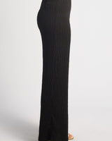 Side view of black high-waisted straight-leg pants in textured jersey fabric with a clean, minimalist silhouette.