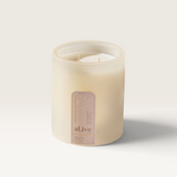 House of Holabox al.ive body soy candle in a frosted glass vessel with an Apricot and Sweet Fig label on marble
