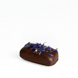 House of Holabox dark chocolate almond caramel crunch truffle topped with blue edible cornflower petals.