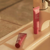 House of Holabox Ashley & Co Lip Punch tinted beeswax lip balm in Pink Beet and Red Radish on a bathroom sink