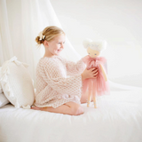 House of Holabox Alimrose Ava angel doll in a blush tulle dress with silver wings held by a smiling young girl