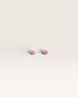 House of Holabox handmade baby pink resin round stud earrings with a smooth finish on a neutral background
