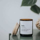 House of Holabox soy candle in an amber glass jar with a wooden lid and baby dictionary meaning label