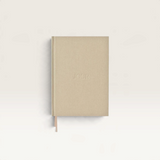 House of Holabox Jour Studio linen planner in beige with embossed text and a matching ribbon bookmark.