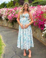 House of Holabox Belle Maxi Dress featuring a blue floral print, twist-front bodice, keyhole cutout, and tie straps.