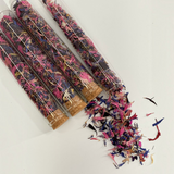 Clear glass test tubes with cork stoppers filled with vibrant dried pink, purple, and blue petals, showcasing The Peel Thing Edible Flower Sprinkles.