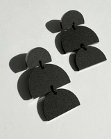 House of Holabox Izzy dangle earrings in black matte acrylic with a sculptural geometric layered design.