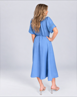 House of Holabox blue midi dress with tie waist, short sleeves featuring cutwork detail, and scalloped hem, back view.