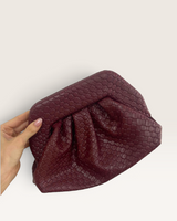House of Holabox Maya clutch in burgundy with a soft gathered construction and a tactile woven-effect finish.