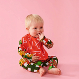 House of Holabox baby wearing a red organic cotton bib with a white candy cane print and matching festive outfit