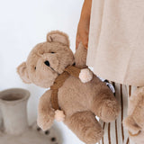 House of Holabox And the Little Dog Laughed caramel plush teddy bear with a knitted scarf held by a child