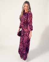 Model wearing House of Holabox Carmel maxi dress in cerise safari animal print with long sleeves and flowing silhouette