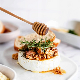 House of Holabox Coast to Coast ceramic brie baker topped with walnuts, rosemary, and honey drizzled from a dipper