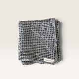 House of Holabox charcoal organic cotton waffle tea towel with a rustic stone-washed texture and brand label.