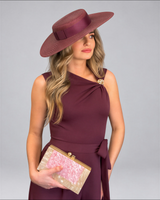 House of Holabox Jasmine jumpsuit in cherry chocolate with asymmetric neckline, gold buckle, and matching wide-brim hat.