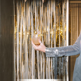 House of Holabox classic margarita cocktail in a salt-rimmed glass held by a person wearing a silver sequin jacket.