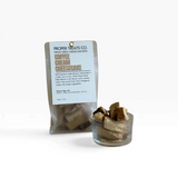 House of Holabox Proper Treats Co. freeze-dried coffee cheesecake bites in a clear pouch and glass bowl.