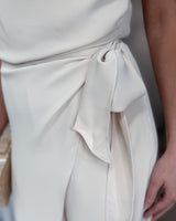 House of Holabox cream jumpsuit featuring a draped waist tie detail for a sophisticated occasion look.
