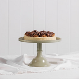 House of Holabox Ecology Torte glass cake stand in sage green holding a chocolate dessert on a white cloth.