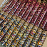 Glass test tubes filled with vibrant dried edible flower petals in pink, purple, yellow tones, showcasing The Peel Thing Edible Flower Sprinkles.