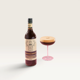 House of Holabox Mr Consistent Espresso Martini cocktail mixer bottle next to a glass with a frothy coffee drink