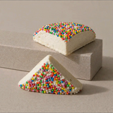 House of Holabox triangle-shaped marshmallows topped with colorful rainbow sprinkles on a neutral background.
