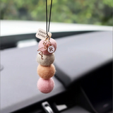 House of Holabox gold-plated enamel flamingo and letter R hanging charms on a multi-coloured felt ball air freshener.