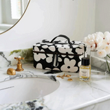 House of Holabox structured cotton canvas toiletry case with a black and white floral print and leather handle.