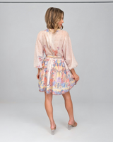 House of Holabox Sara mini dress in yellow floral print with pastel blooms, billowing sleeves, and tie waist, back view