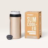 House of Holabox Huski slim can cooler in champagne gold with a black lid, can tab slider, and matching product box.