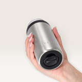 House of Holabox Huski slim stainless steel can cooler held in hand, featuring a black lid and insulated design.