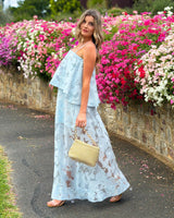 House of Holabox icy blue sheer floral tiered midi dress with adjustable straps worn by a woman outdoors